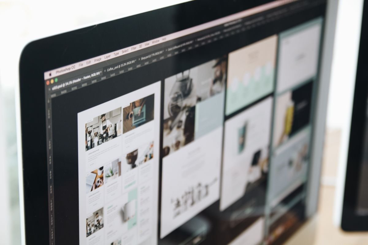 Computer monitor displaying website design mockups in Photoshop